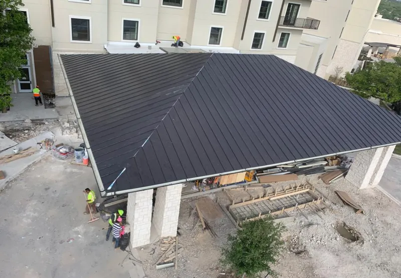 Metal roofing installation team working on a commercial building in Belfast